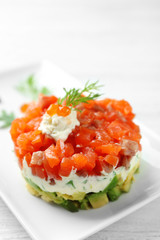Delicious salmon tartare with red caviar on white plate