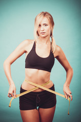 Fitness girl measuring her waistline