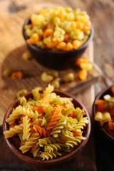 Different types of pasta on wooden background