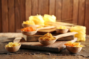Different types of pasta on wooden background