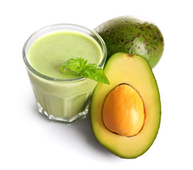 Glass of fresh avocado smoothie and avocado fruit isolated on white