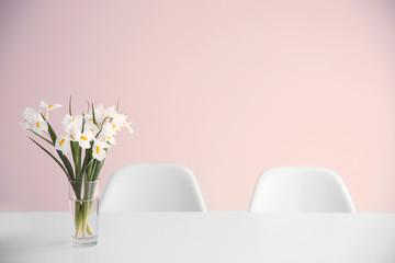 Beautiful white iris flowers on dinning table against white wall background