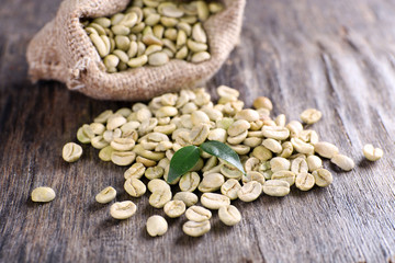 Green coffee beans in a bag  on wooden table