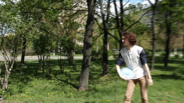 Guy and girl throwing frisbee in the green park, 4K, UHD, UltraHD