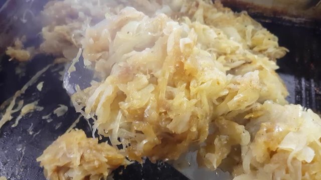 Chef is frying onions crispy and golden, at a restaurant kitchen