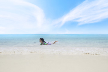 Fototapeta na wymiar Happy little girl playing on the tropical beach