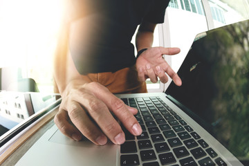 Designer hand working with laptop computer on wooden desk as res