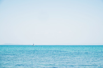 Fototapeta na wymiar Horizon, blue ocean and clear sky with sailing boat 