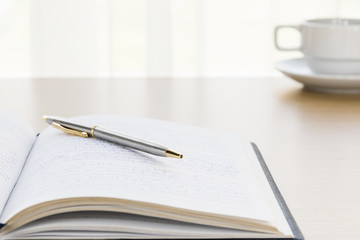 Pen put on a book with on the desk