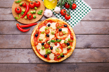 Delicious pizza with cheese and vegetables on wooden background