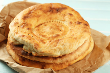 Flat bread on craft paper on wooden background
