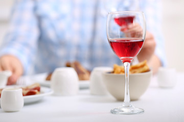 Dinner with glasses of wine on light blurred background