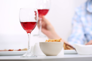 Dinner with glasses of wine on light blurred background