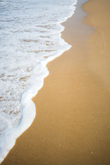 White wave on brown sand beach