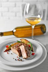Delicious grilled steak on plate with white wine