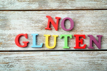 Phrase NO GLUTEN made of colorful letters on wooden background