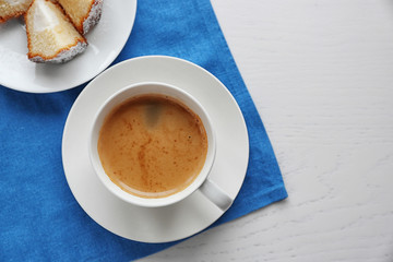 Cup of coffee with cake on a blue napkin