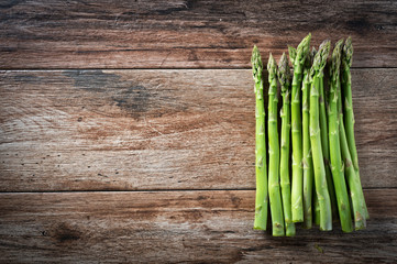 Bunch of fresh asparagus on wooden rustic background. Copy space