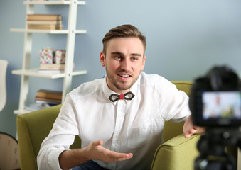 Young male blogger recording video at home