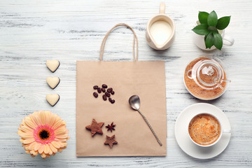 Cop of coffee and brown sugar on wooden table, top view