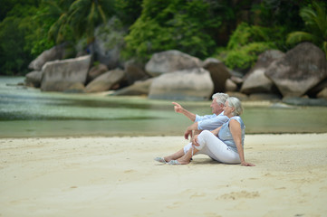 elderly couple rest at tropical beach
