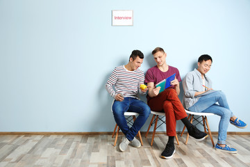 Three men waiting for interview indoors