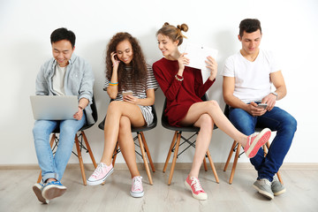 Fototapeta premium Group of people with digital devices waiting for interview indoors
