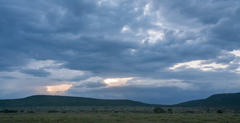 Fototapeta na wymiar Savanna plain at dawn against storm cloud sky background. Serengeti National Park, Tanzania, Africa. 