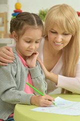 Girl painting with mother