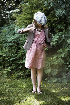 Girl looking through magnifying glass