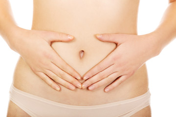 Woman is having heart shape made from hands on her belly