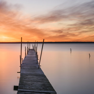 Fototapeta Wooden pier and lake at sunset