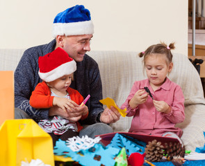 Naklejka premium Girls with Dad doing holiday crafts.