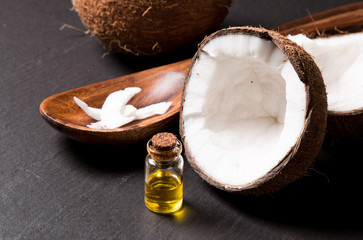 coconut oil and fresh coconuts on black stone