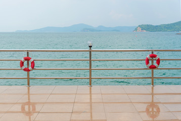 red Lifebuoy on railing by the sea