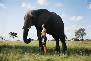 Woman standing next to elephant