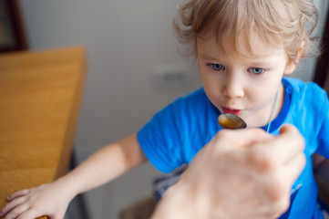 baby drinks with a teaspoon