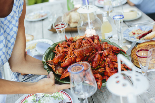 Close up of woman placing bowl of crayfish on table