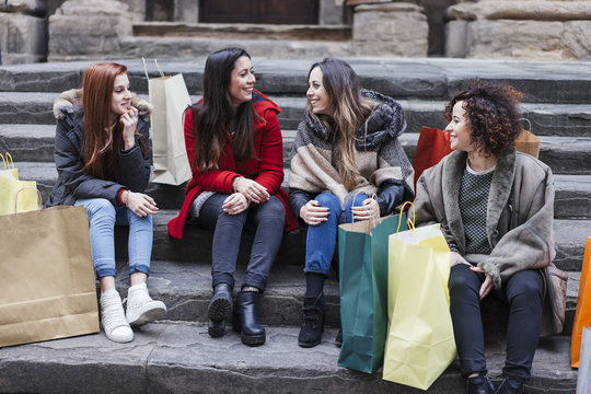 Happy female group of friends doing shopping together