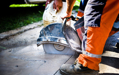 Construction worker cutting Asphalt paving for sidewalk - obrazy, fototapety, plakaty