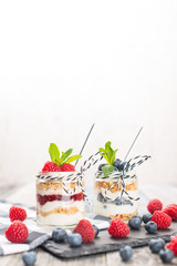 Jars with fresh yogurt and berries on table
