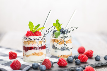Jars with fresh yogurt and berries on table