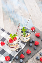 Jars with fresh yogurt and berries on table