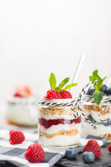 Jars with fresh yogurt and berries on table