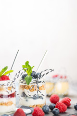 Jars with fresh yogurt and berries on table