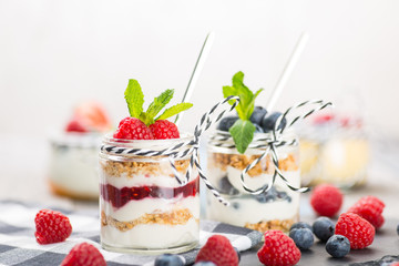 Jars with fresh yogurt and berries on table
