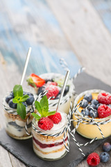 Jars with fresh yogurt and berries on table