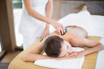Obraz na płótnie Canvas Woman receiving stone massage at spa