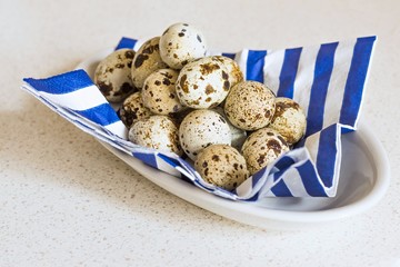 Group of quail egg on blue-white striped napkin on plate