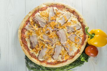 tasty pizza on a wooden board with beautiful vegetables and sauc